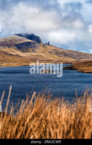 Isle of Skye, Schottland - das wunderschöne Loch Fada (See Fada) und die schneebedeckten Gipfel des Old man of Storr an einem sonnigen Frühlingsmorgen mit blauem Himmel und Wolken Stockfoto