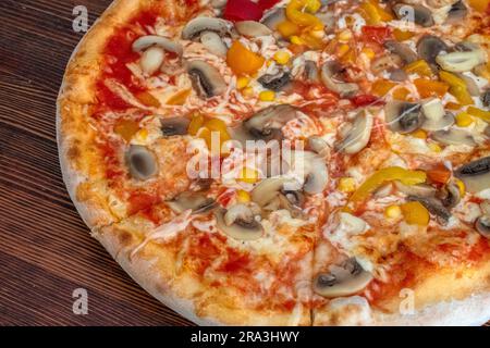 Pilzpizza: Eine leckere Pizza mit Tomatensoße, geschmolzenem Käse, aromatischen Pilzen, lebendigem Paprika und Zuckermais, Alle auf einem evu Stockfoto