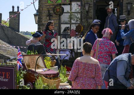 Haworth 1940er Jahre nostalgische Retro-Living-History-Nachstellung von WW2 (Stand & Fußweg zum geschäftigen Ladeneingang) - Main Street, West Yorkshire, England, Großbritannien. Stockfoto