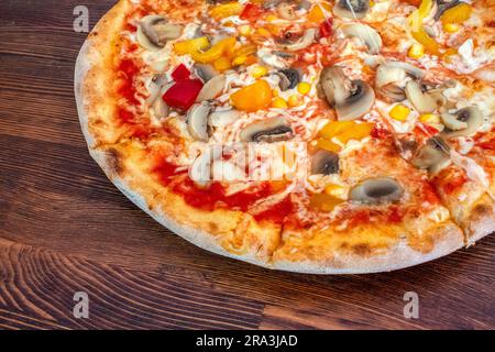 Pilzpizza: Eine leckere Pizza mit Tomatensoße, geschmolzenem Käse, aromatischen Pilzen, lebendigem Paprika und Zuckermais, Alle auf einem evu Stockfoto