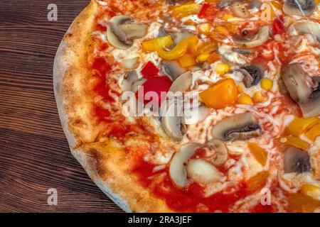 Pilzpizza: Eine leckere Pizza mit Tomatensoße, geschmolzenem Käse, aromatischen Pilzen, lebendigem Paprika und Zuckermais, Alle auf einem evu Stockfoto