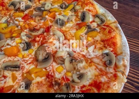 Pilzpizza: Eine leckere Pizza mit Tomatensoße, geschmolzenem Käse, aromatischen Pilzen, lebendigem Paprika und Zuckermais, Alle auf einem evu Stockfoto