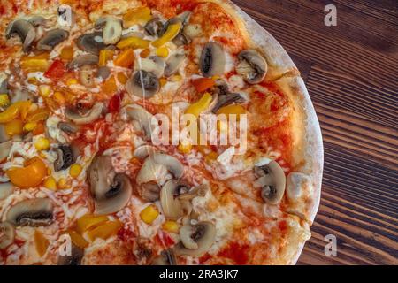 Pilzpizza: Eine leckere Pizza mit Tomatensoße, geschmolzenem Käse, aromatischen Pilzen, lebendigem Paprika und Zuckermais, Alle auf einem evu Stockfoto