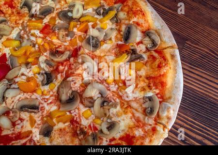 Pilzpizza: Eine leckere Pizza mit Tomatensoße, geschmolzenem Käse, aromatischen Pilzen, lebendigem Paprika und Zuckermais, Alle auf einem evu Stockfoto