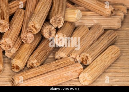 Ein Stapel Eichendübel auf Eichenhintergrund. Dübel wurden verwendet, um zwei Holzstücke, Gelenke, Schreiner zu verbinden Stockfoto