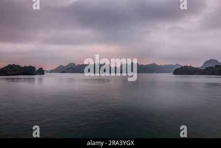 Ein malerischer Blick auf eine Gruppe kleiner Inseln, umgeben von einer riesigen Wasserfläche bei Sonnenuntergang Stockfoto