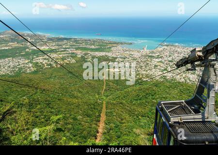 Blick auf Puerto Plata, den Wald, das Meer und die Seilbahn vom Gipfel des Mount Isabel de Torres - die Seilbahn befindet sich oben. In der Dominikanischen Republik. Stockfoto