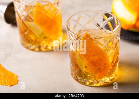 Hausgemachte, altmodische Cocktail-Erfrischung Bourbon Whiskey, Zuckerwürfel und aromatische Bitter, garniert mit einer Orangenschale Stockfoto