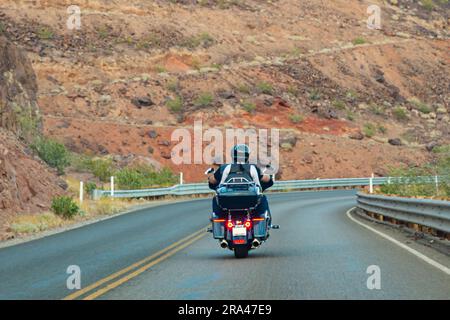 Motorradtour durch Amerika. Ein paar Radfahrer fahren auf dem Highway vor dem Hintergrund der Felsen, Blick nach hinten. Nicht erkennbare Biker auf einem Motorrad Stockfoto