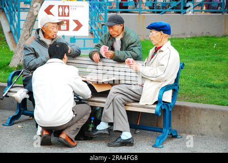 Ältere asiatische Freunde spielen Karten am Portsmouth Square in Chinatown, San Francisco Stockfoto