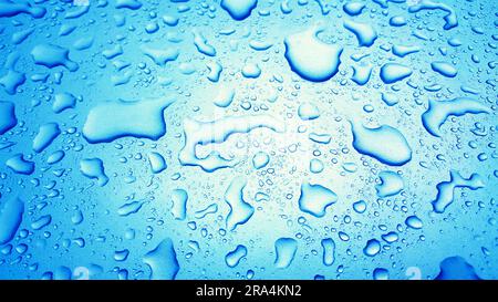 Wassertropfen Hintergrund auf blauer glänzender Oberfläche, Regentropfen auf blauer Textur für Kosmetika, Getränkeprodukte. Stockfoto