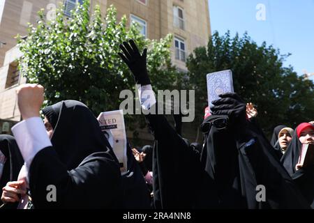 Teheran, Teheran, Iran. 30. Juni 2023. Iranische Demonstranten singen Slogans, da einer von ihnen eine Kopie von Koran, dem heiligen Buch des Islam, während eines Protests gegen die Verbrennung eines Korans in Schweden vor der schwedischen Botschaft in Teheran, Iran, am Freitag, den 30. Juni 2023, hochhält. Am Mittwoch verbrannte ein Mann, der sich in den schwedischen Medien als Flüchtling aus dem Irak ausgab, einen Koran vor einer Moschee im Zentrum Stockholms. (Kreditbild: © Sobhan Farajvan/Pacific Press via ZUMA Press Wire) NUR REDAKTIONELLE VERWENDUNG! Nicht für den kommerziellen GEBRAUCH! Stockfoto