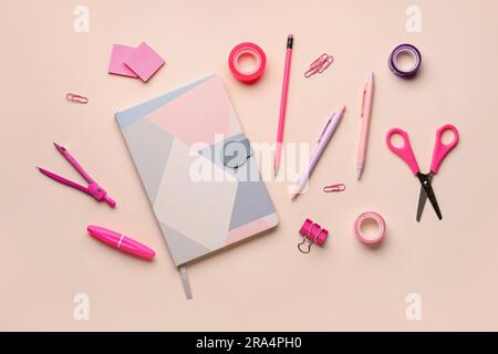 Komposition mit Notizbuch und Schreibwaren auf pinkfarbenem Hintergrund Stockfoto