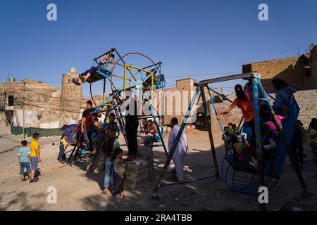 Mosul, Irak. 29. Juni 2023. Irakische Kinder spielen in einem mobilen Vergnügungspark, während sie Eid al-Adha in der Altstadt von Mosul im Norden Iraks feiern. (Foto: Ismael Adnan/SOPA Images/Sipa USA) Guthaben: SIPA USA/Alamy Live News Stockfoto