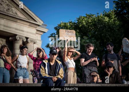 Paris, Frankreich. 30. Juni 2023. Eine Frau trägt ein Plakat mit der Aufschrift "Police are rassisist and kill children" während eines Protests in Paris, Frankreich, Freitag, den 30. Juni 2023. Der französische Innenminister sagt, dass es in einer vierten Nacht der Unruhen einen "Absturz" gegeben hat, mit 471 Verhaftungen im Vergleich zu 917 in der vorherigen Nacht. In mehreren französischen Städten wurde jedoch von weiteren Gewalttaten berichtet.die Unruhen begannen am Dienstag nach dem Polizeischuss auf einen 17-jährigen Jungen algerischer Abstammung namens Nahel M. der Beamte, der Nahel erschossen hat, entschuldigte sich bei der Familie, aber der Tod des Teenagers hat die Klagen wieder aufleben lassen Stockfoto