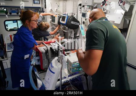 Fortgeschrittene Krankenschwester Sarah Hardwick (Zentrum) zusammen mit Senior Staff Nurse Jayne Farrance (links) und Ambulance Technician Blair McMurray (rechts) verlassen das East Surrey Hospital, nachdem sie einen jungen Patienten in einem von Sanitätern betriebenen Krankenwagen vom South Thames Retrieval Service (STRS), einem Intensivpflegedienst, abgeholt haben. Transport schwerkranker Kinder und Jugendlicher von örtlichen Krankenhäusern zu pädiatrischen Intensivstationen und Intensivstationen in der Region Süd-Themse mit speziell ausgerüsteten Krankenwagen. Foto: Freitag, 16. Juni 2023. Stockfoto