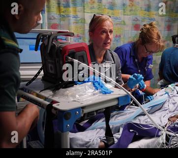 Die Advanced Nurse Practitioner Sarah Hardwick (Zentrum) unterstützt neben der Senior Staff Nurse Jayne Farrance (rechts) und dem Ambulance Technician Blair McMurrary (links) die Verlegung ihres jungen Patienten auf eine pädiatrische Intensivstation in St. George's Hospital nach dem Transport vom East Surrey Hospital in einem Krankenwagen, der von Sanitätern des South Thames Retrieval Service (STRS) betrieben wird, einem Intensivpflegedienst, der schwerkranke Kinder und Jugendliche von örtlichen Krankenhäusern zu pädiatrischen Intensivstationen und Intensivpflegestationen in der Region Süd-Themse transportiert, Über Special eq Stockfoto