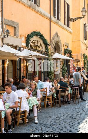Malerisches Straßencafé-Restaurant in einer gepflasterten Straße, Rom, Latium, Italien Stockfoto