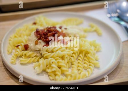 Carbonara Fusilli Pasta mit knusprigem Speck auf dem Teller Stockfoto