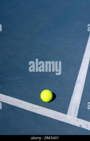 Nahaufnahme des Tennisballs, der an einem sonnigen Tag auf dem Tennisplatz liegt, Kopierraum Stockfoto