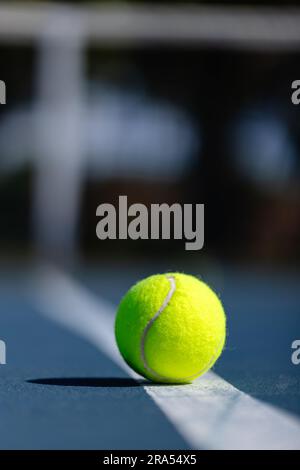 Nahaufnahme des Tennisballs, der an einem sonnigen Tag auf dem Tennisplatz liegt, Kopierraum Stockfoto