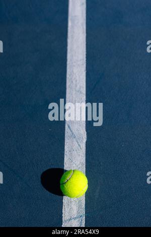 Nahaufnahme des Tennisballs, der an einem sonnigen Tag auf dem Tennisplatz liegt, Kopierraum Stockfoto