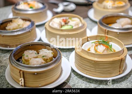 Verschiedene Dimsum im Streamkorb auf dem Tisch Stockfoto