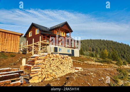 Herbst Landschaft mit den ersten unerwarteten Schnee und Herbst Laub. Alte Holzhütten auf einem berghügel Stockfoto