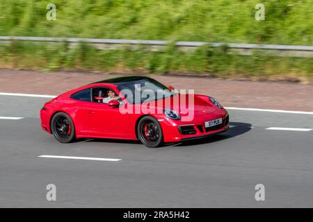 2023 Porsche 911 Carrera GTS S-A, PDK Auto Red Car Coupe Benzin 2981 cm3; Fahrt mit hoher Geschwindigkeit auf der Autobahn M6 im Großraum Manchester, Großbritannien Stockfoto