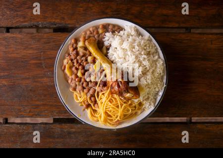 Merienda de la Chakra mit Huhn, Reis und Hülsenfrüchten. Traditionelles Gericht der Menschen, die auf den Feldern des peruanischen Dschungels arbeiten. Stockfoto