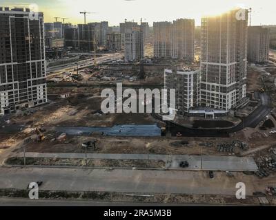 Eine neue Nachbarschaft in der Stadt. Aufnahmen aus der Höhe. Urbane Landschaft. Hohe mehrstöckige Gebäude aus Glas in verschiedenen Farben und Höhen stehen Stockfoto