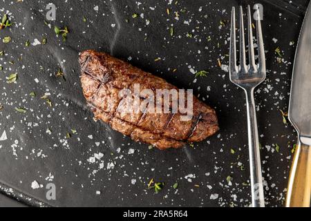 Fleischklößchen mit gegrilltem Cheddar auf einem Steinschneidebrett im Steakhouse-Restaurant Stockfoto