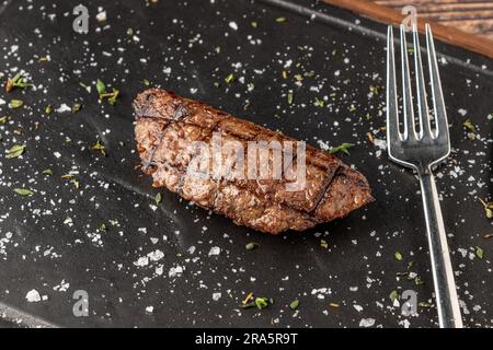 Fleischklößchen mit gegrilltem Cheddar auf einem Steinschneidebrett im Steakhouse-Restaurant Stockfoto