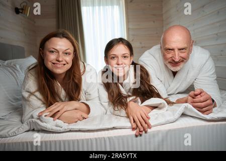 Eine dreiköpfige Familie, die morgens im Schlafzimmer war Stockfoto
