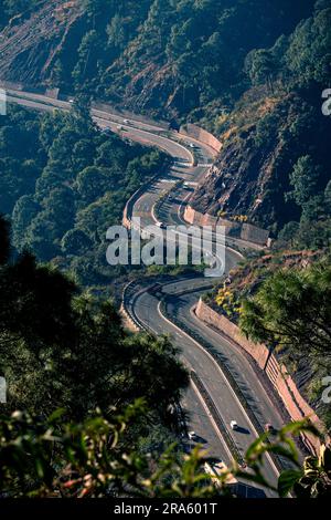 Wunderschöner Blick aus der Vogelperspektive auf eine lange kurvige Nationalstraße von Himachal Pradesh in Indien; Reisen Sie auf einer langen Straße mit landschaftlicher Schönheit und Sonnenschein Stockfoto