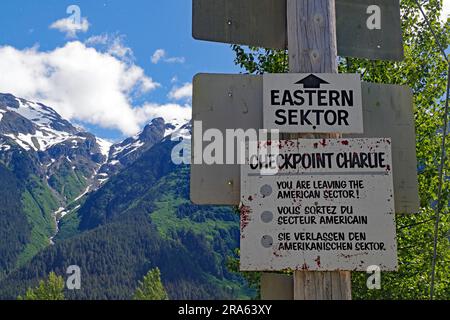 Ein Schild weist darauf hin, dass der östliche Sektor verlassen wird, hohe Berge im Hintergrund, Checkpoint Charlie, Geisterstadt Hyder, Alaska, USA Stockfoto