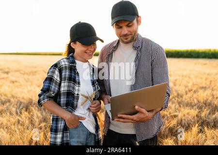 Ein paar Bauern untersuchen das Getreidefeld. Stockfoto