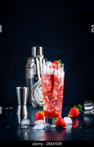 Rotes alkoholisches Cocktailgetränk mit Wodka, Grapefruitsaft, Erdbeeren, Zucker und heißem Chili-Pfeffer. Highball-Glas auf dunkelblauem Hintergrund Stockfoto