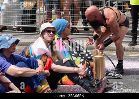 Piccadilly, London, Großbritannien. 1. Juli 2023. Just Stop Oil Demonstranten haben die Pride London Parade gestoppt, indem sie die Straße besprüht und vor dem Coca-Cola-Floß gesessen haben. Sie werfen Coca Cola vor, der größte Plastikverschmutzer der Welt zu sein. Die Teilnehmer der Parade wurden mit ihnen zum Umzug reanimiert Stockfoto