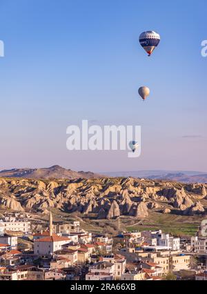 Ein Bild von Heißluftballons, die bei Sonnenaufgang über der Stadt Goreme fliegen. Stockfoto