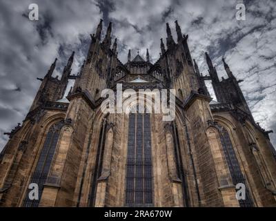Rückansicht des Veitsdoms auf der Prager Burg, Tschechische Republik. Dramatische gotische Architektur mit hohen spitzen Türmen, Steinfassade und großem Bogen Stockfoto