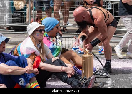 Piccadilly, London, Großbritannien. 1. Juli 2023. Just Stop Oil Demonstranten haben die Pride London Parade gestoppt, indem sie die Straße besprüht und vor dem Coca-Cola-Floß gesessen haben. Sie werfen Coca Cola vor, der größte Plastikverschmutzer der Welt zu sein. Die Teilnehmer der Parade wurden mit ihnen zum Umzug reanimiert Stockfoto