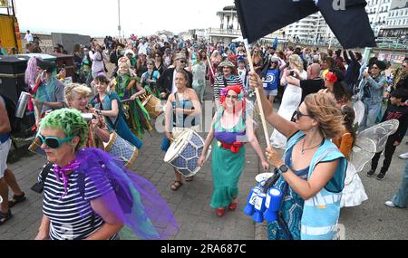 Brighton UK 1. . Juli 2023 - heute nehmen an der Parade der Meerjungfrauen entlang der Küste von Brighton Teil . Die jährliche Parade ist eine Feier des Meeres und macht das Bewusstsein für die Erhaltung der Meeresumwelt und die Sauberkeit des Wassers schärfer : Credit Simon Dack / Alamy Live News Stockfoto