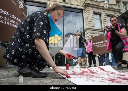 Berlin, Deutschland. 01. Juli 2023. 1. Juli 2023, Berlin, Deutschland: In Berlin wurde der Hugo Boss Store, ein Leuchtfeuer der deutschen Luxusmode, am 1. Juli 2023 zur Bühne für einen Protest. Unter ukrainischen Flaggen versammelten sich Demonstranten vor dem Laden und verwandelten das Modezentrum in einen Ort politischer Ausdrucksfähigkeit und Widerstand. Die Botschaft der Demonstranten war klar und deutlich: "Hugo Boss, skandalös!" Es war ihr Rallying Cry, ein direkter Vorwurf für die Fortsetzung der Geschäftstätigkeit des Unternehmens in Russland trotz des anhaltenden Konflikts mit der Ukraine. "Keine Geschäfte mit Russland", schrien sie Stockfoto