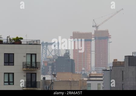New York, USA. 30. Juni 2023. Blick auf die Williamsburg Bridge zeigt die schlechte Luftqualität und schlechte Sicht aufgrund der kanadischen Waldbrände. Stockfoto