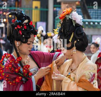 Hongkong, China -- 11. März 2023. Eine Chinesin hilft einem Model mit ihrem Hochzeitsanzug. Stockfoto