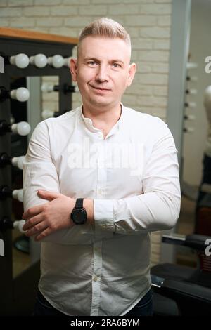 Ein blonder Mann in einem leichten Hemd steht im Zimmer Stockfoto