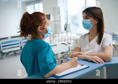Arzte, die am Schreibtisch in der Reanimationskammer sprechen Stockfoto
