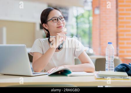 Asiatische Studentenuniversität Teenagerin mit fröhlichem Denken neue Idee Kreativität Lernkonzept. Stockfoto
