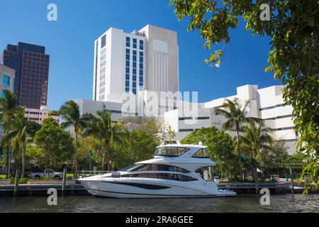 Fort Lauderdale, Florida, USA. Blick über den New River, luxuriöser Motorboot-Fahrer, der unter moderner Downtown-Architektur vertäut ist. Stockfoto